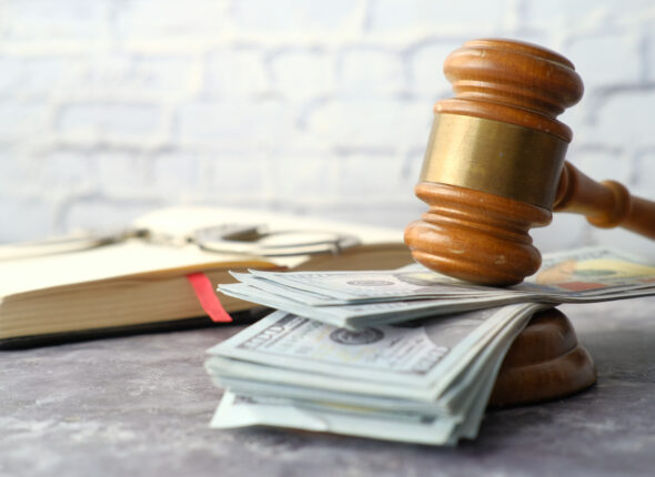 close up of gavel and cash on wooden background