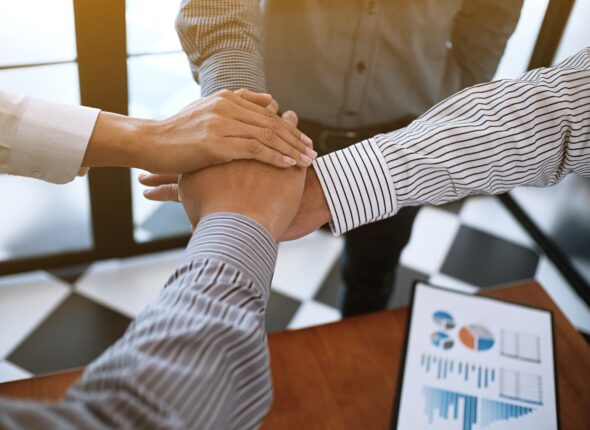 Business partnership putting hands together.