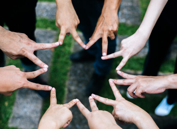 Women and men friends make star shape from fingers. Success, fri